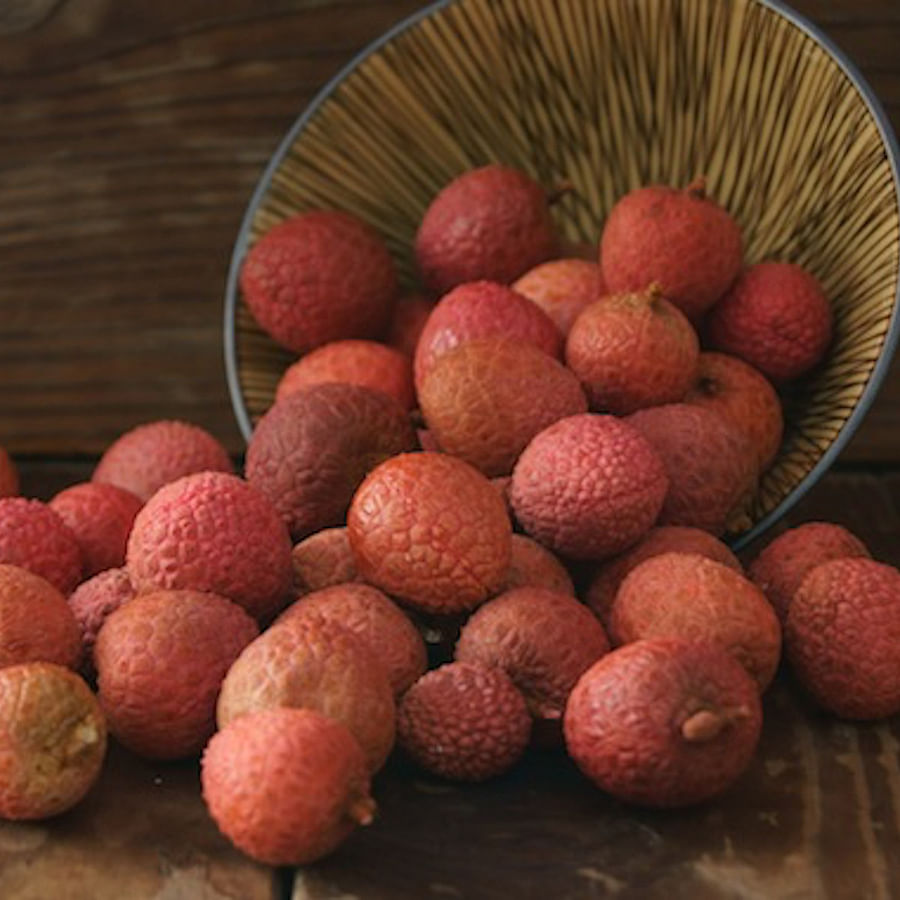 Fresh lychees with some peeled revealing juicy flesh